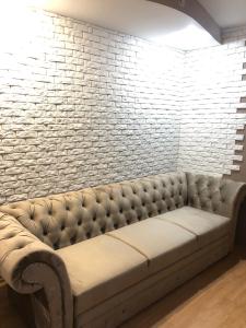 un sofá en una habitación con una pared de ladrillo en Adventure, en Kiev