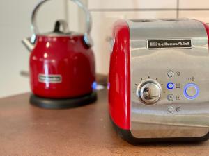 a red and silver toaster sitting on top of a counter at THE PANAMERICANA, Air-Conditioned, 4K HD TV, Bose, Lounge in Riedstadt