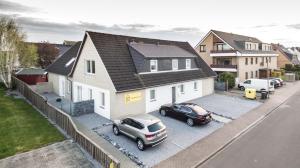 una casa con dos coches aparcados en un estacionamiento en dat geele hus Nr. 3, en Büsum