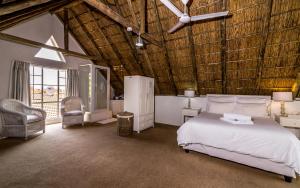 a bedroom with a white bed and a wooden ceiling at Green Park Manor in Johannesburg