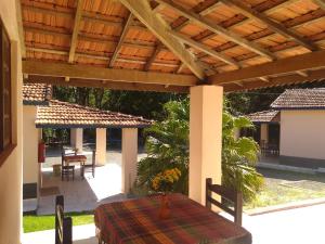 a patio with a table and a wooden pergola at Pousada e Pesqueiro Trem do Peixe in Monte Alegre do Sul