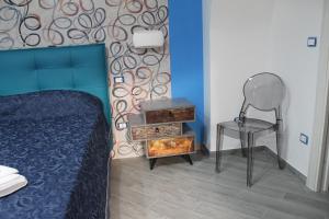 a bedroom with a bed and a chair and a table at casavacanzeivana in Pizzo