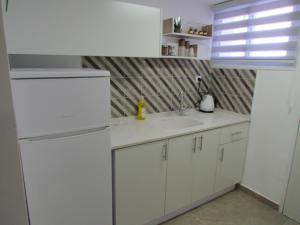 een keuken met een witte koelkast en een wastafel bij Eleni apartment Eilat in Eilat