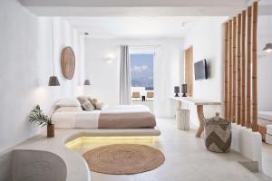 a white bedroom with a bed and a bath tub at Naxian Utopia | Luxury Villas & Suites in Stelida