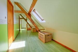 an attic room with a staircase and wicker baskets at Gîtes "LA JUMEL" à 25 min du Touquet, à la Campagne et à la Mer in Beaurainville