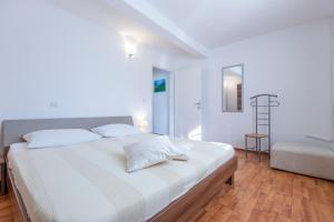 a white bedroom with a large bed with white sheets at Holiday house Mary in Barban +22 photos