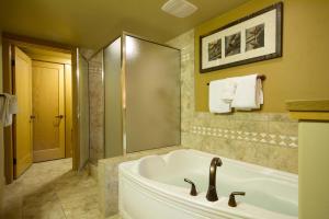a bathroom with a tub, sink, mirror and bathtub at Club Wyndham Steamboat Springs in Steamboat Springs