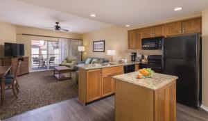 a kitchen with a black refrigerator and a living room at Club Wyndham Branson at The Meadows in Branson