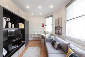 a living room with a couch and a tv at COVENT GARDEN PIAZZA RESIDENCE in London