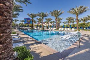 a pool with chairs and palm trees in a resort at Club Wyndham Desert Blue in Las Vegas