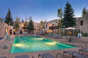 a swimming pool with chairs and a building at WorldMark Taos in Taos