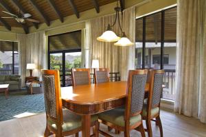 uma sala de jantar com uma mesa de madeira e cadeiras em Club Wyndham Ka Eo Kai em Princeville