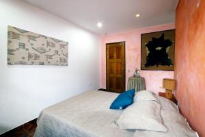 1 dormitorio con cama y pared con puerta en Aparthotel Los Pinos en Boquete