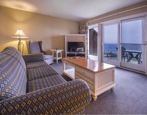 Sala de estar con sofá y mesa con vistas al océano en Club Wyndham Newport Overlook en Jamestown