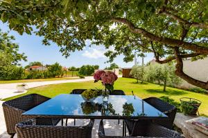 a blue table with a vase of flowers on it at Holiday house Mary in Barban