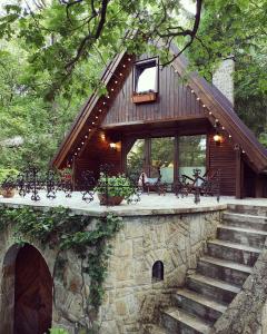 a log cabin with a porch and stairs leading to it at kiskalács in Kismaros