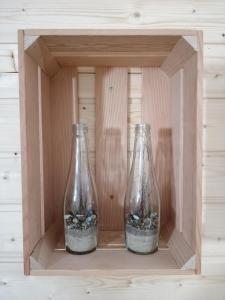two glass vases with rocks in a wooden box at Pogodny Domek in Mielno