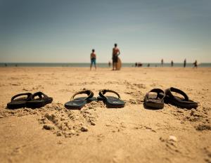 four pairs of flip flops sitting on a beach at Hotel Tybee in Tybee Island