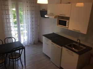 a small kitchen with a sink and a table with a tableablish at Residence Abamar in Rimini +10 photos
