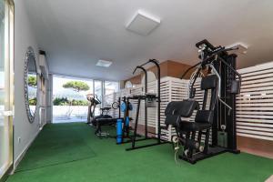 un gimnasio con máquinas de correr y alfombra verde en Hotel Giovanella, en Bellaria-Igea Marina