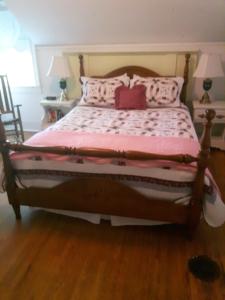 a bedroom with a large bed with a pink comforter at Gables Bed & Breakfast in Stayner