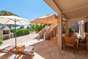 a patio with a table and chairs and an umbrella at Holiday home Privlaka/Zadar Riviera 8218 in Batalaži