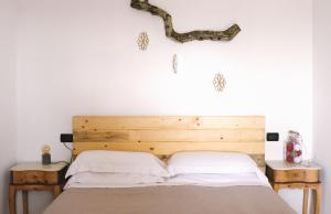 a bedroom with a bed with a branch on the wall at Agriturismo Le Site in Corigliano dʼOtranto