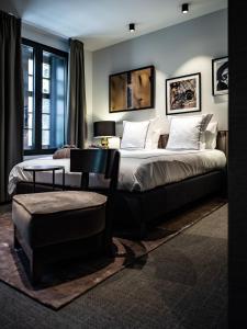 a bedroom with two beds and a table and a chair at Boutiquehotel 't Fraeyhuis in Bruges