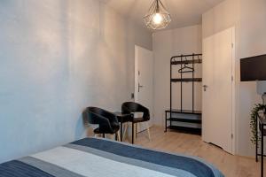 een slaapkamer met een bed, een bureau en stoelen bij Aparthotel STUDIO in Krakau