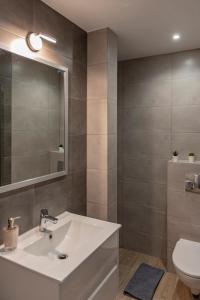 een badkamer met een wastafel, een spiegel en een toilet bij Aparthotel STUDIO in Krakau