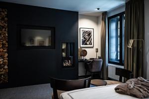 a bedroom with black walls and a bed and a desk at Boutiquehotel 't Fraeyhuis in Bruges