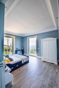 a bedroom with blue walls and a bed and windows at Le Fratte Luxury Home in Castellammare di Stabia