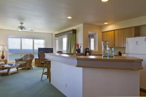 a kitchen with a counter and a living room at Club Wyndham Shearwater in Princeville