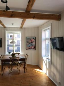 ein Esszimmer mit einem Tisch und einem TV in der Unterkunft House of the Snowbird in Reykjavík