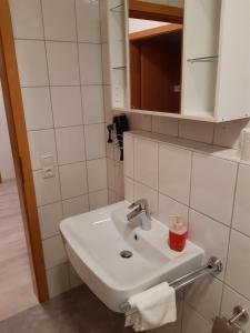 une salle de bain avec un lavabo blanc et un miroir dans l'établissement Riverside, à Füssen 31 autres photos