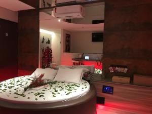 ein Zimmer mit einem Bett mit grünen Blättern darauf in der Unterkunft ViaSul Motel in Ceilândia