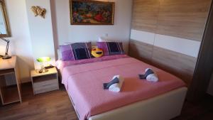 a bedroom with a pink bed with shoes on it at Casa Bozzero in Krnica