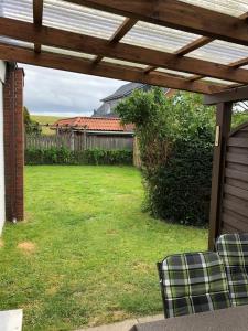 a backyard with a wooden pergola and a yard at Großer Hookie in Hooksiel