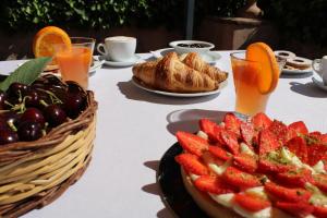 une table avec des fruits et des croissants et une assiette de fraises dans l'établissement IL Ciliegio Dell 'Etna, à Giarre