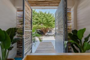 a pivot door opens up to a backyard with a wooden deck at Studios Downtown Cancun in Cancún