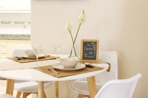 mesa de comedor con mesa blanca y sillas en La casita de Triana, en Cambados