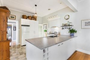 a kitchen with white cabinets and a counter top at HogmortHomes Neale Street in Bendigo