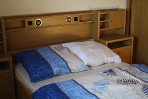 a bed with a wooden headboard and two pillows at Ferienhaus Cilla in Beltheim