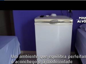 a washing machine sitting next to a purple wall at Pousada Alvorada in Riachão
