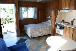 a bedroom with a bed and a desk at Apollo Bay Holiday Park in Apollo Bay