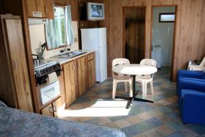 a kitchen with a stove, sink, and refrigerator at Apollo Bay Holiday Park in Apollo Bay