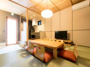 - une salle à manger avec une table et des chaises en bois dans l'établissement MUSUBI HOTEL MACHIYA Haruyoshi, à Fukuoka