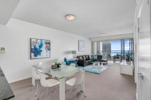 a living room with a table and chairs at Sierra Grand Broadbeach - GCLR in Gold Coast