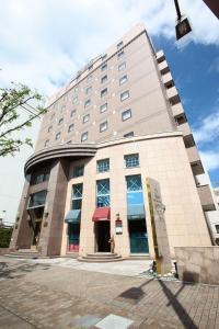 duży budynek z czerwoną markizą w obiekcie Hotel Quest Shimizu w mieście Shizuoka