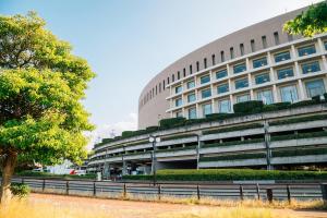 een groot gebouw met een hek ervoor bij TRIP POD SUMIYOSHI A in Fukuoka